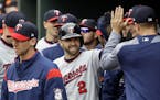 Brian Dozier high-fives teammates in the dugout after scoring on an RBI double by Kennys Vargas in the first inning against the Baltimore Orioles on W