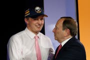 Casey Mittelstadt, left, shakes hands with NHL Commissioner Gary Bettman after being selected by the Buffalo Sabres in the first round of the NHL hock