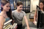 The Erbes sisters, Maia, 14, and Erin, 16, checked out books at the Burnhaven Library in Burnsville with their mom, Lisa Erbes. Teens like these can u