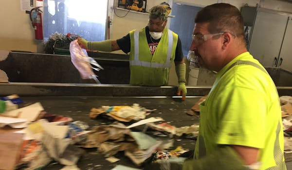 Workers at Dem-Con’s recycling center in Shakopee raced to remove non-recyclable items before they enter the sorting machines.