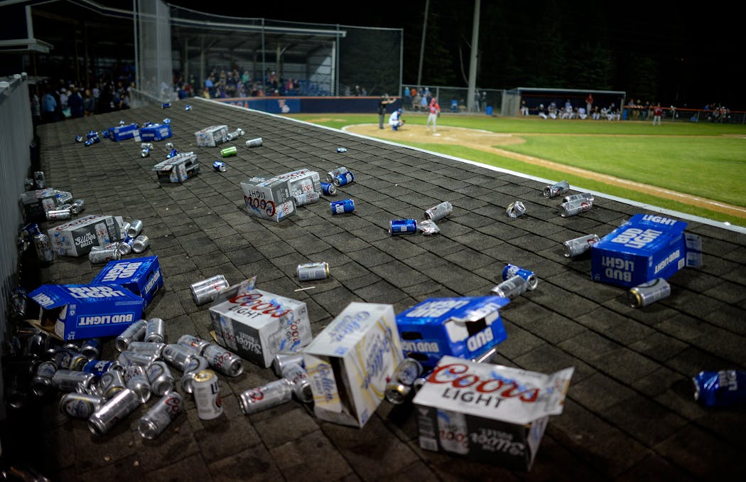 Fans make a game of tossing their empties onto the dugout roof.