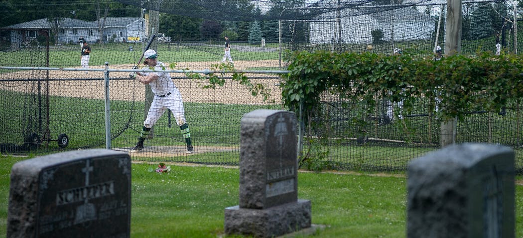 An Atwater player practiced batting in the cages at the Farming Flames Baseball field on Sunday, June 25, 2017 in Farming, Minn. The field butts up against the town’s cemetery.