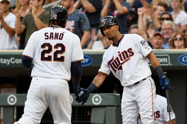 Minnesota Twins' Miguel Sano (22) is congratulated by Eddie Rosario, right, after Sano scored on a double by Robbie Grossman off Detroit Tigers pitche
