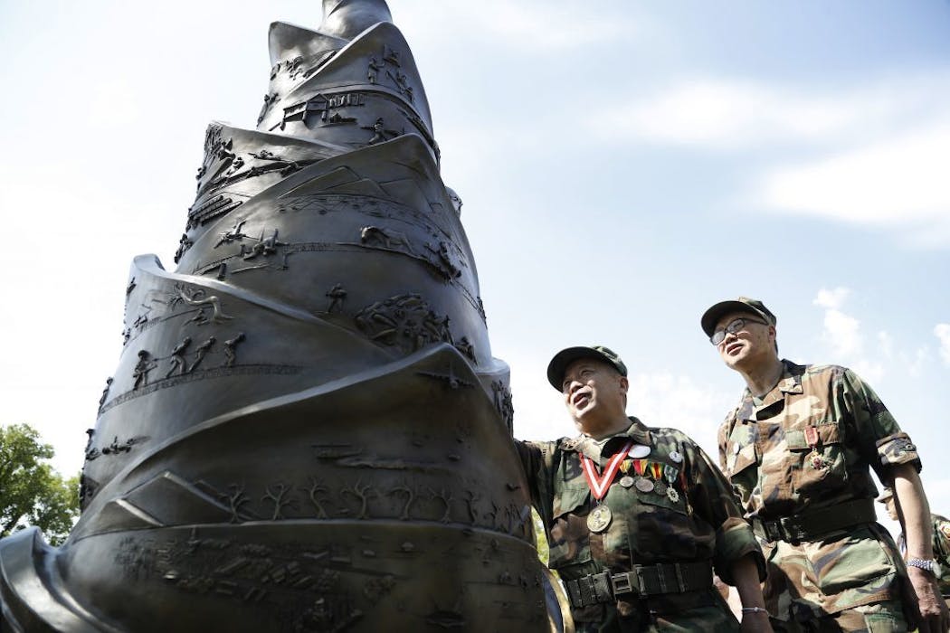 Lieutenant Xai Vang, left, and Cheng Vang looked over the monument during a service in May at the Hmong/Lao Veteran Statue to honor and remember those who died fighting for American causes in Laos at the State Capitol.