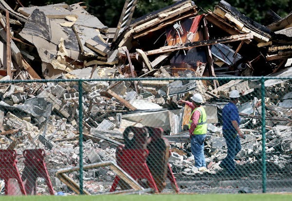 Two days after an explosion and building collapse at Minnehaha Academy that left two dead and several injured, officials look over the site Friday, Au