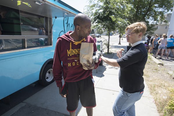 Pastor Margaret Kelly, right, talked with Lucky King who picked up food from Shobi's Table food truck in St. Paul.