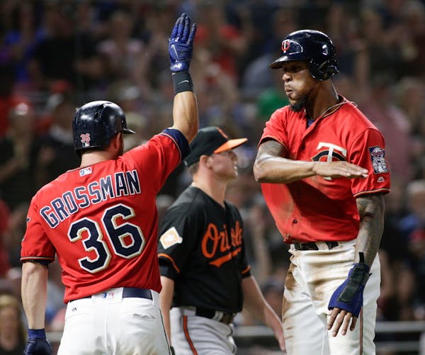 Minnesota Twins' Byron Buxton celebrates with teammate Robbie Grossman after he scored from first on a Brian Dozier single during the eighth inning of