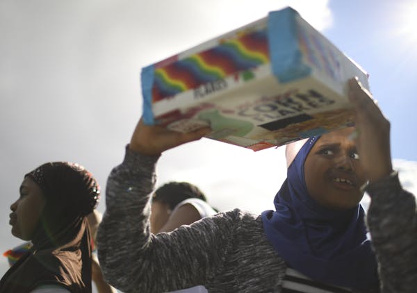 Birna Hassan, 9, tried to see the sun with a pinhole projector camera she made at Brooklyn Park Library on Thursday.