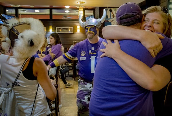 Scott “Skolt” Asplund, center, and Cyrea Lynch, left, joined fans at Jake’s Stadium Pizza in Mankato. The city is losing the Vikings training ca