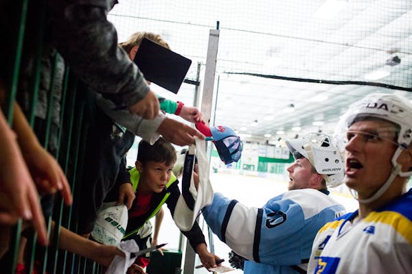 Nick Bjugstad (right) and Zane McIntyre signed autographs for kids after their games in Da Beauty League on a recent Monday.