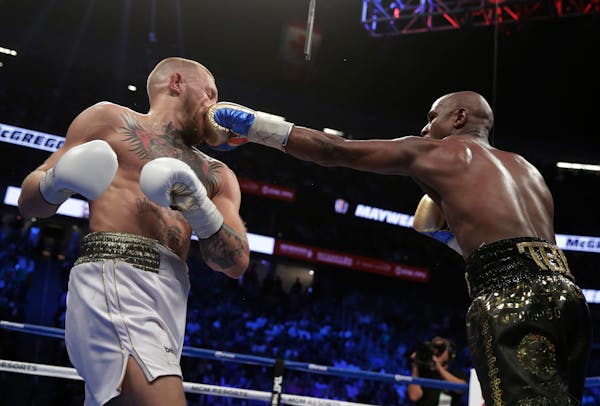 Floyd Mayweather Jr. jabs Conor McGregor in a super welterweight boxing match Saturday, Aug. 26, 2017, in Las Vegas. (AP Photo/Isaac Brekken)