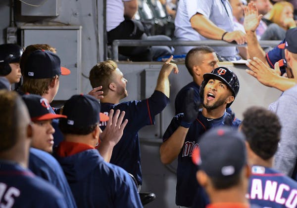 Minnesota Twins' Eddie Rosario, right, celebrates in the dugout after he hit a two-run home run against the Chicago White Sox during the sixth inning 