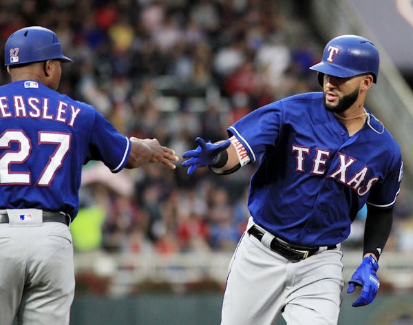 Texas Rangers' Nomar Mazara, right, is congratulated by third base coach Tony Beasley (27) after hitting a two-run home run against the Minnesota Twin