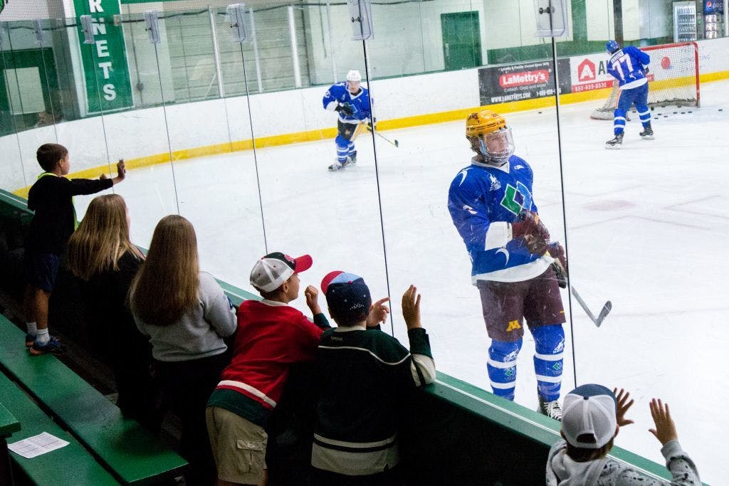 Children lean over the glass for autographs from Da Beauty League players.