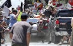 People fly into the air as a vehicle drives into a group of protesters demonstrating against a white nationalist rally in Charlottesville, Va., Saturd