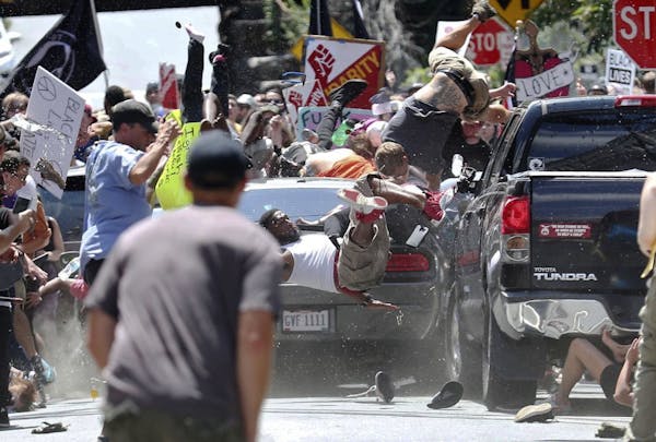 People fly into the air as a vehicle drives into a group of protesters demonstrating against a white nationalist rally in Charlottesville, Va., Saturd