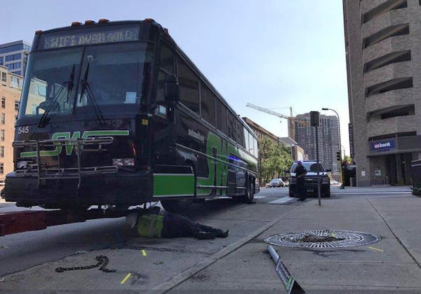 A tow truck driver attached a chain to a bus that was damaged in a collision with a limousine Saturday in downtown Minneapolis.