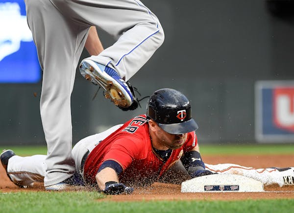 After tagging back to second base following a fly out by Twins first baseman Joe Mauer to center field, second baseman Brian Dozier slid safely into t