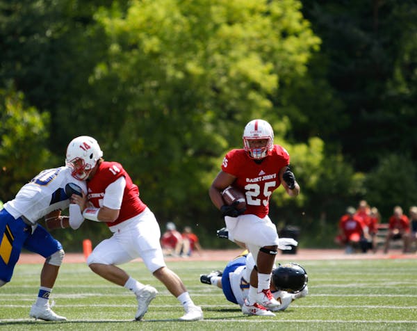 St. John's running back Kai Barber looks for open field after a block from quarterback Ben Alvord on Saturday against St. Scholastica.