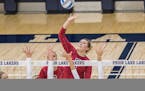 Lakeville North junior Tori Thompson tips the ball over two Prior Lake defenders Thursday night in Prior Lake. The Panthers defeated theLakers in four
