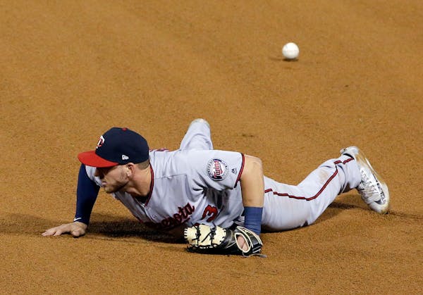 Minnesota Twins first baseman Mitch Garver makes a fielding error after Chicago White Sox's Nicky Delmonico hit the ball during the fourth inning of a