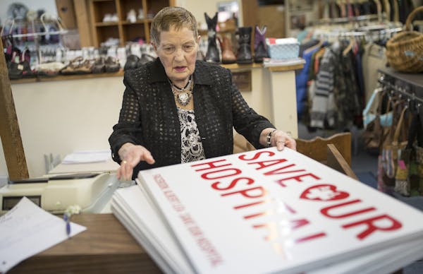 Rita Andersen stacked signs at Mary-Go-Round Shoppe, part of Albert Lea residents' campaign against their Mayo Clinic-run hospital.