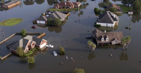 In this aerial photo, homes sit in floodwaters caused Tropical Storm Harvey in Port Arthur, Texas, Friday, Sept. 1, 2017. Port Arthur's major roads we