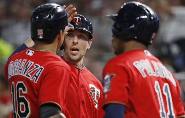 Ehire Adrianza, left, and Jason Castro, center, scored on a Joe Mauer single in the second inning against the Padres.