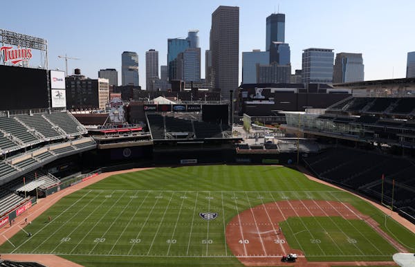Groundskeepers worked to transform Target Field from a baseball to a football configuration in preparation for Saturday’s game between St. Thomas an