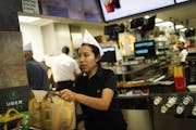 Lorena Sanchez served an order to go as the Roseville McDonald's celebrated 60 years of business with 60-cent hamburgers and wearing throwback uniform