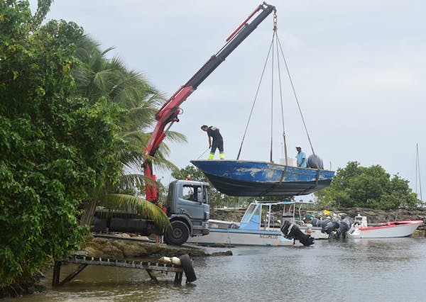 Men remove boats from the water ahead of Hurricane Maria in the Galbas area of Sainte-Anne on the French Caribbean island of Guadeloupe, early Monday,
