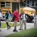 Mastery School students make their way off the school bus in August at a Minneapolis charter school that's part of the Harvest Network.