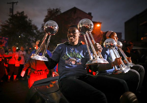 Minnesota Lynx players Sylvia Fowles, left and Maya Moore held up all four WNBA Championship trophies as they arrived at Williams Arena for their titl
