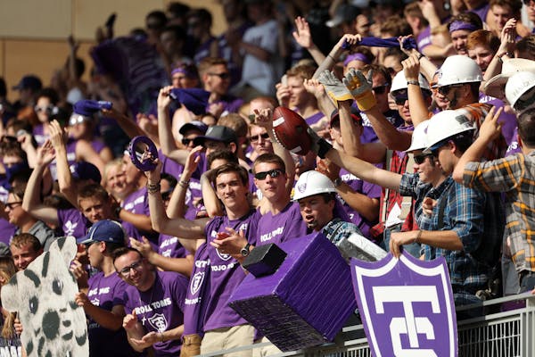 University of St. Thomas fans celebrated in the stands with the football after kicker Bryan Steinsapir made a field goal in the first half.