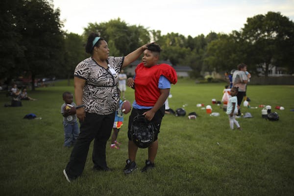 Kathryn Lusack checked in with her son, Roderick Bright, 11, when he took a water break during football practice Tuesday evening at Knob Hill Park in 