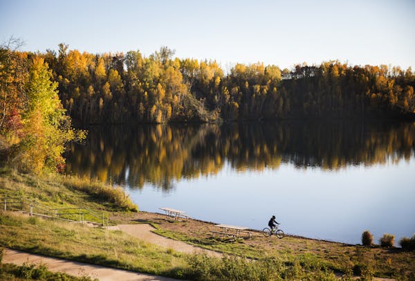 A bicyclist soaked in the fall colors at Cuyuna Country State Recreation Area. Biking, hiking and water sports have revived the mining region.