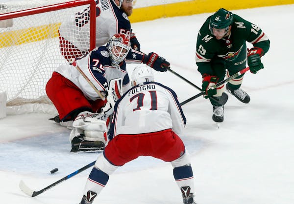 Columbus Blue Jackets goalie Sergei Bobrovsky, left, of Russia, stops a shot as Minnesota Wild's Luke Kunin, right, looked for a rebound during the fi