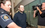 Joshua Boyle, center, is escorted by authorities to a media availability at Toronto's Pearson International Airport, Friday, Oct. 13, 2017. Boyle, his