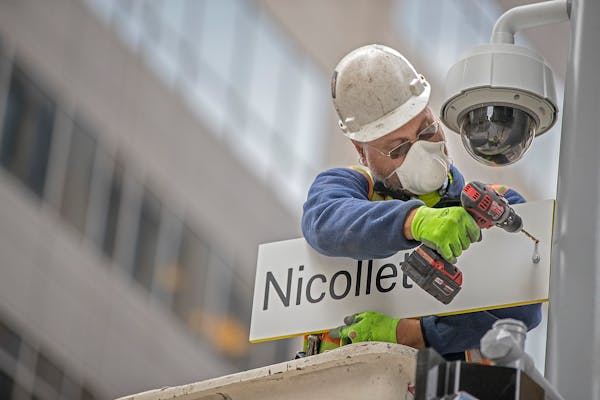 Jason Gehrke of Albrecht Signs installed new signs at 8th and Nicollet along the Nicollet Mall, Friday, October 13, 2017 in Minneapolis, MN.