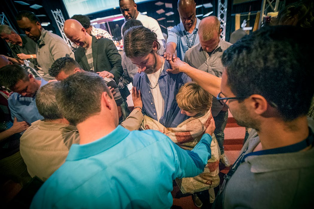 Flanked by his sons, Alex Farchmin received prayers at his treatment graduation ceremony. 