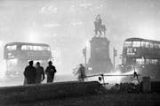 Double-decker buses circled the Prince Albert statue at Holborn Circus in London, England, in the smog at night on Dec. 6, 1952.