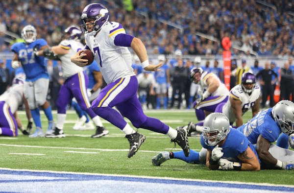 Minnesota Vikings quarterback Case Keenum (7) split two Lions defenders for a first quarter touchdown at Ford Field Thursday November 23, 2017 in Detr