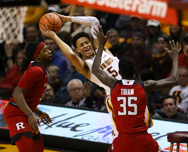 Gophers guard Amir Coffey was smothered by the defense of Rutgers guard Issa Thiam (35) and forward Deshawn Freeman (33) in the first half.