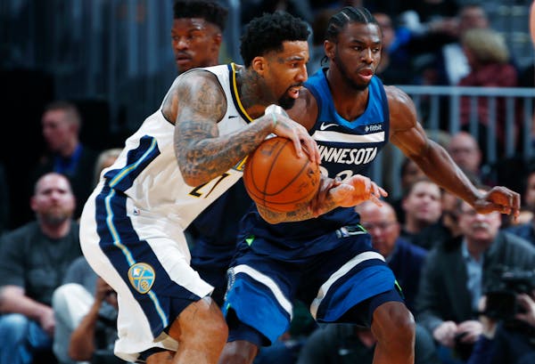 Denver Nuggets forward Wilson Chandler, front, drives past Minnesota Timberwolves forward Andrew Wiggins in the first half of an NBA basketball game W