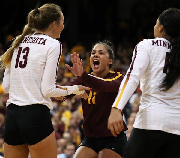 Libero Dalianliz Rosado, center, celebrated a point with two of her Gophers teammates in a recent match.