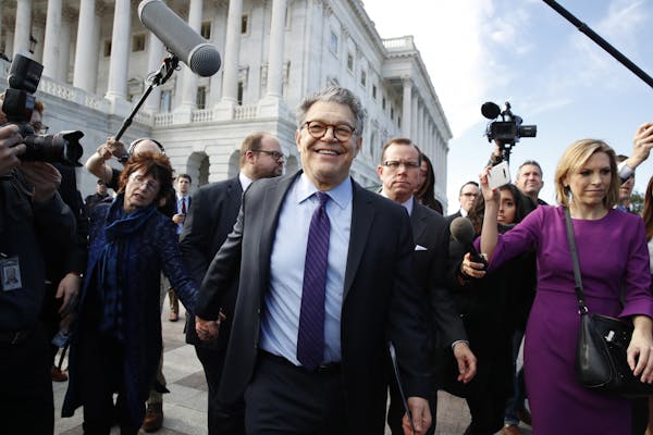 Sen. Al Franken, D-Minn., center, held hands with his wife, Franni Bryson, as he left the Capitol after announcing that he will resign in the coming w