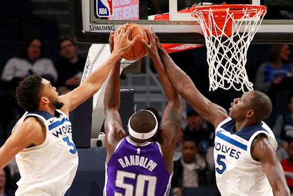 Timberwolves players Karl-Anthony Towns and Gorgui Dieng block Kings forward Zach Randolph