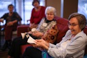 Ruth Fingerson demonstrated a time-travel concept with a piece of paper during discussion of “A Wrinkle in Time” at Summit Place in Eden Prairie.