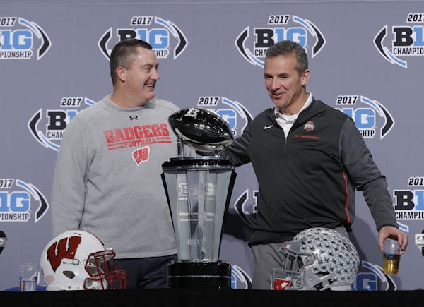 Wisconsin coach Paul Chryst shared a smile with Ohio State counterpart Urban Meyer during a news conference for the Big Ten championship game Friday i