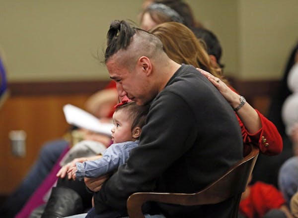 Savanna LaFontaine-Greywind's boyfriend Ashston Matheny holds their daughter, Haisley Jo, as victim impact statements are read during the sentencing o